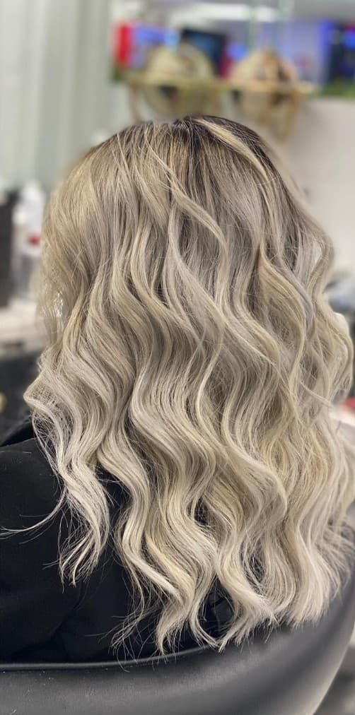 Icy blonde balayage with soft curls back view at R&M Salon