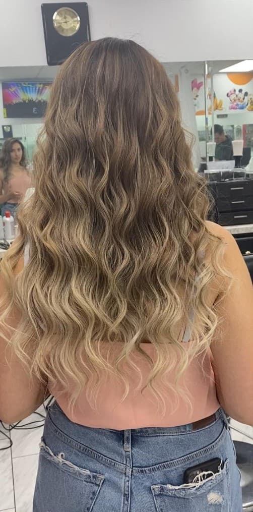Dimensional brunette to blonde balayage with beachy waves at R&M Salon